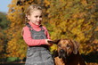 Blondes Mädchen spielt mit ihrem Hund (Australian Ridgeback)