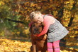 Blondes Mädchen umarmt ihren Hund (Australian Ridgeback)